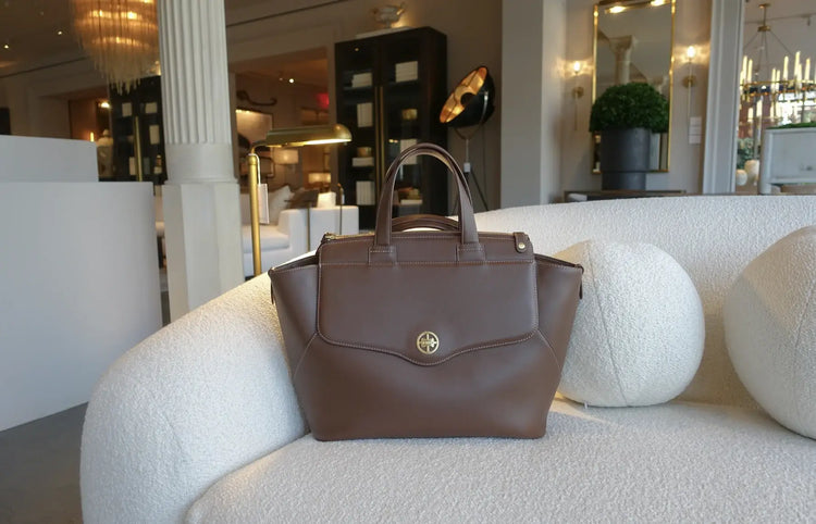 a brown bag on a white couch